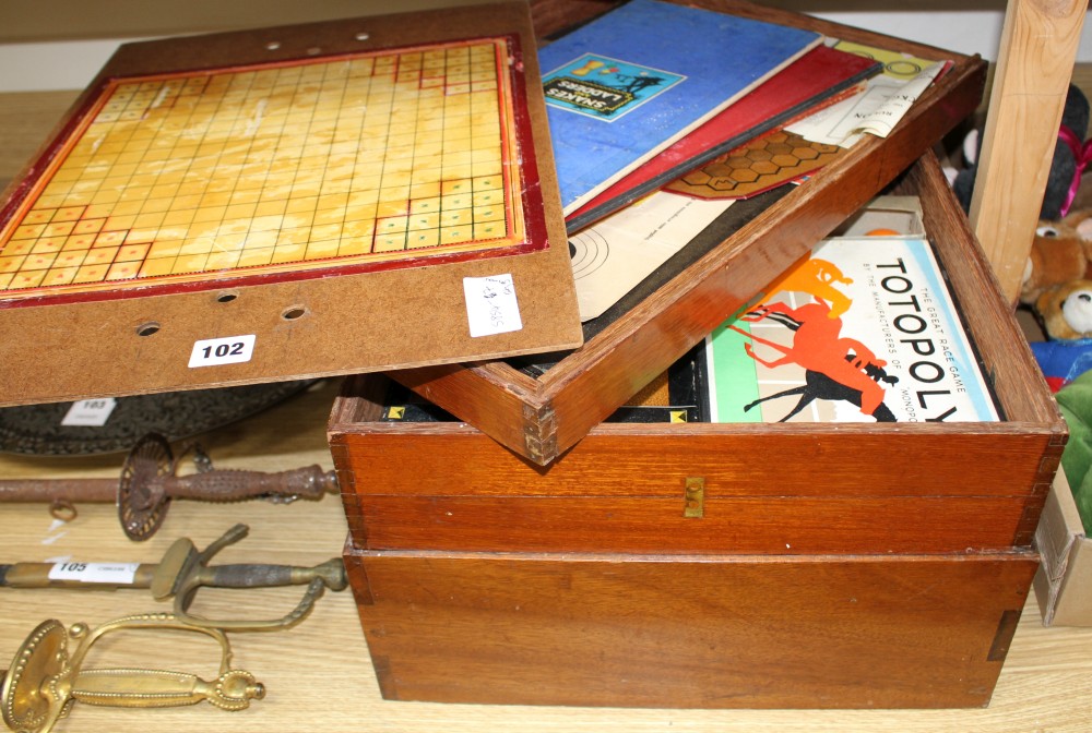 A quantity of assorted toys and games in a stacking three tier box